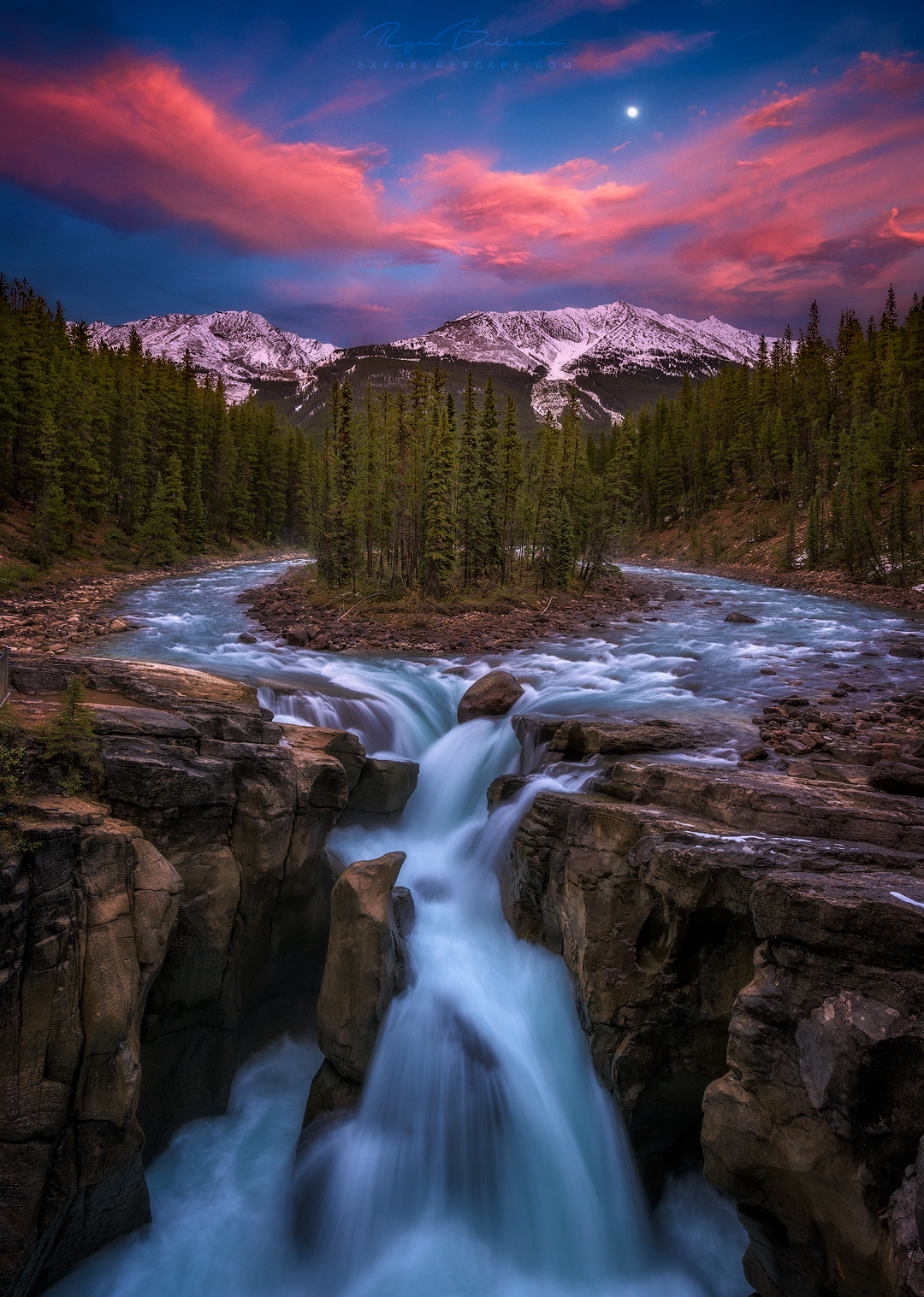 Sunwapta waterfall at sunset with moon in jasper national park in Canada